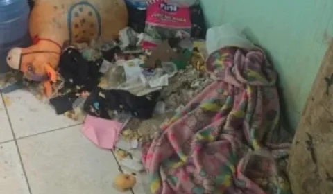 Menino de 2 anos é encontrado sozinho em casa cheia de lixo; mãe é presa em MG