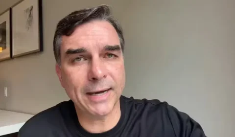 Sai o Flavinho moderado de terninho e entra o Flávio Bolsonaro de sandália Rider “Tá Okei”